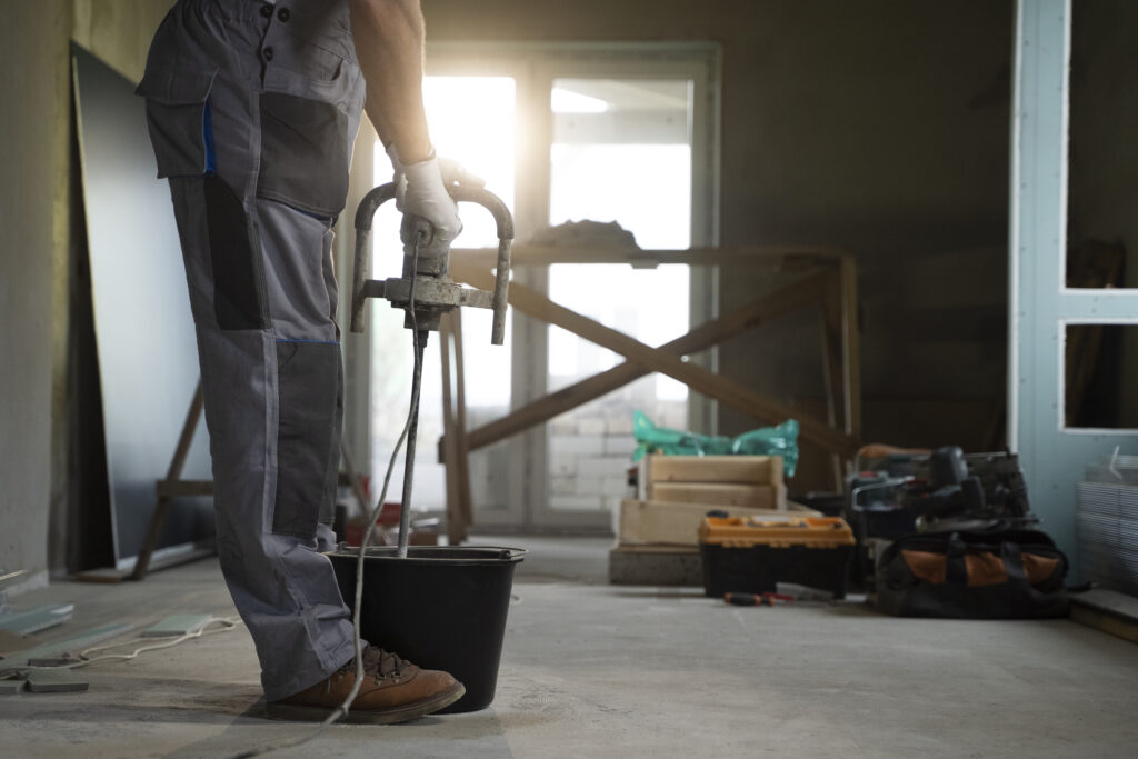 Handwerker im Rohbau beim Anrühren von Zement